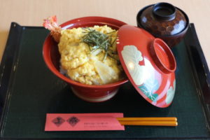 岐阜市の美豚で提供されている満腹丼。黄色の卵でとじられた揚げ物の下にご飯が並ぶ。赤い丼に盛り付けられた満腹丼。