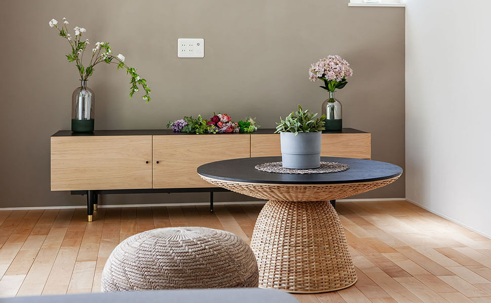 円形のデザインテーブル、スツール。壁にはライトブラウンのローテーブルが並ぶ。岐阜市の家具シャルドネ