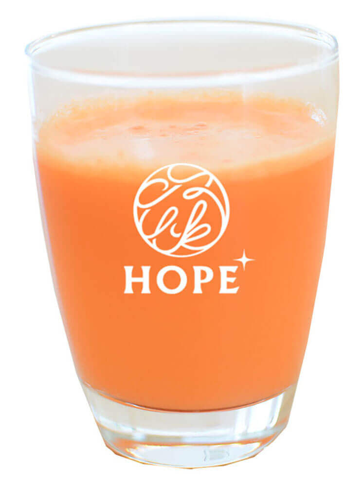 ガラスコップに入ったオレンジ色のジュース
