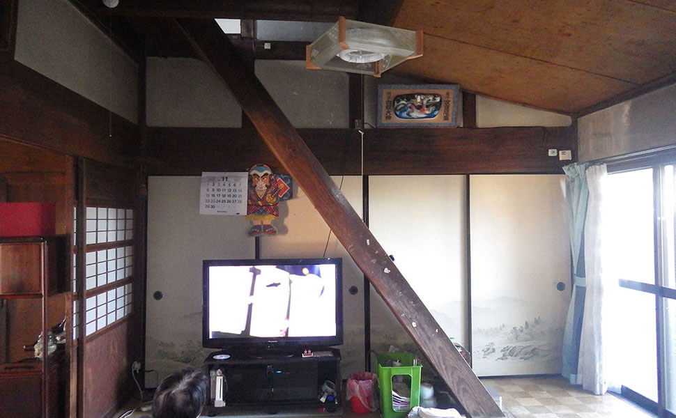 リビングは畳で、テレビが置かれ、その横にすぐ階段が。