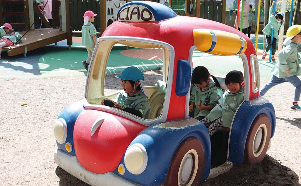 赤と青の車の乗り物で遊ぶ園児複数名