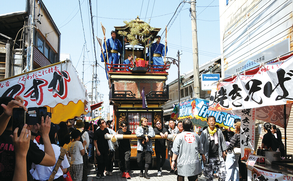 出店が並ぶ竹鼻商店街を曳行する山車。